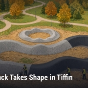 Fostoria News Pump track with winding curves and autumn trees in Tiffin park.